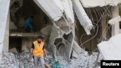 Un travailleur humanitaire du Croissant-Rouge inspecte les fournitures dispersés médicales après un raid aérien sur un dépôt médical dans le quartier Tariq al- Bab d'Alep tenue par les rebelles , en Syrie , le 30 Avril , 2016