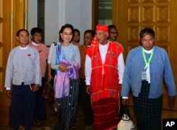 Myanmar opposition leader Aung San Suu Kyi, second from left, walks with members of her National League for Democracy party upon their arrival to attend regular session of the parliament's Lower House in Naypyitaw, Myanmar, Dec 1, 2015.