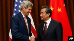 지난달 16일 중국을 방문한 존 케리 미국 국무장관(왼쪽)이 왕이 외교부장과 만나 악수하고 있다. (자료사진)