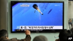 South Korean people watch a TV screen showing a graphic of North Korea's rocket launch, at a train station in Seoul, April 13, 2012.