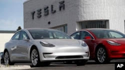 FILE - New 2018 Model 3 vehicles are seen on a Tesla dealer's lot in Littleton, Colorado, April 15, 2018.