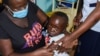 Jeywellan Ochieng, 2, yang dipangku oleh ibunya Julliet Achieng (kiri) bereaksi setelah menerima vaksin anti malaria di klinik kesehatan untuk Ibu dan Anak di wilayah Gem, Siaya, Kenya, pada 7 Oktober 2021. (Foto: Reuters: James Keyi) 