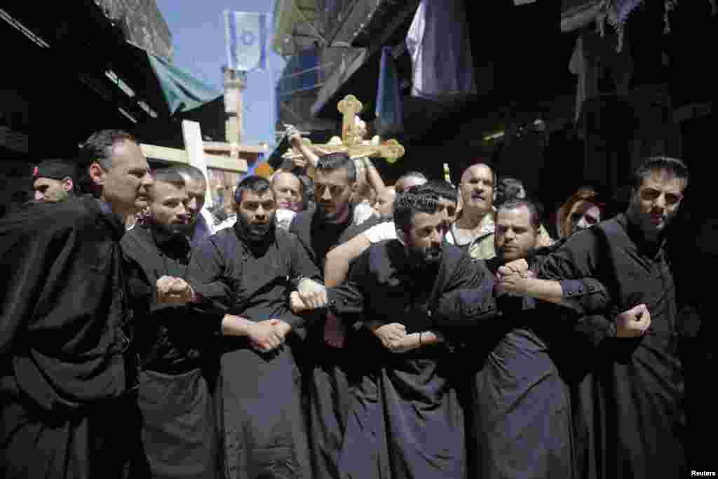 Christian worshippers lock arms during a procession along the Via Dolorosa on Good Friday during Holy Week in Jerusalem&#39;s Old City, April 18, 2014.&nbsp;