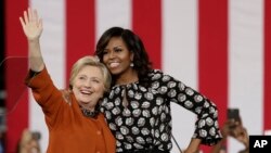 Kandidat presiden AS dari Partai Demokrat Hillary Clinton bersama ibu negara Michelle Obama dalam kampanye di Winston-Salem, North Carolina (27/10). (AP/Chuck Burton)