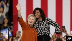លោក​ស្រី​ Clinton នៅឯ​យុទ្ធនាការ​ឃោសនា​បោះ​ឆ្នោត ដែល​អម​ដំណើរ​ដោយ​លោក​ស្រី Michelle Obama នៅ​ Winston-Salem រដ្ឋ North Carolina កាល​ពី​ថ្ងៃ​ទី​២៧ ខែ​តុលា។
