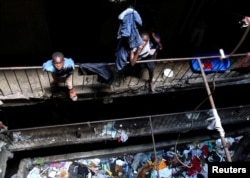 FILE - Children stand amid trash in a building earmarked for demolition in the Mathare neighborhood of Nairobi, Kenya, May 17, 2016.