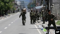 Government troopers patrol their area as fighting continues for the sixth day between the military and Muslim rebels, Sept. 14, 2013 at Zamboanga city in southern Philippines. 