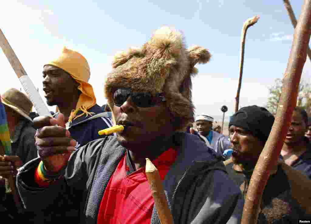 Striking miners chant slogans as they gather at the AngloGold Ashanti mine in Carletonville, northwest of Johannesburg, South Africa, October 25, 2012. 