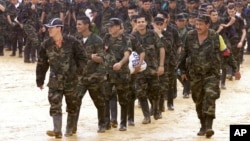 El comandante guerrillero conocido como "Grannobles" (derecha), acompaña a algunos de los 242 policías y soldados que fueron capturados por la guerrilla de las FARC en la población colombiana de La Macarena.