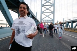 Alvaro Bautista, of Camden, N.J., crosses the Benjamin Franklin Bridge to later hear Pope Francis celebrate Sunday Mass in Philadelphia, Sept. 27, 2015.