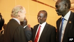 Taban Deng Gai (center), chief negotiator from South Sudan's opposition at peace talks in Addis Ababa, shakes hands with an unidentified observer. 