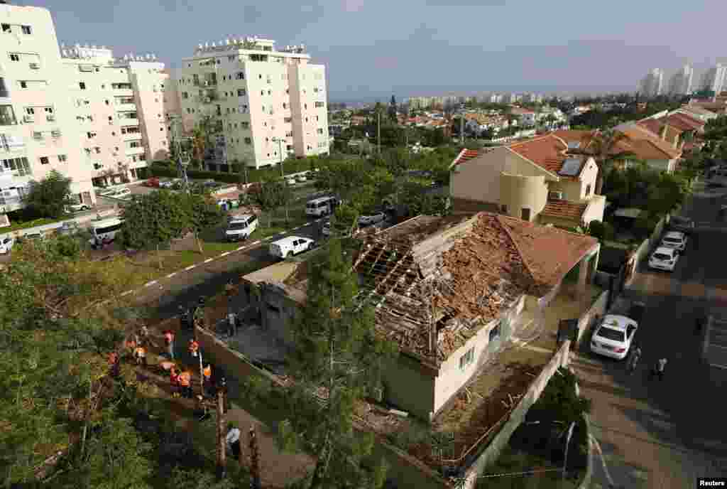Israeli emergency personnel surround a house that was struck by a rocket, fired from Gaza, in the southern coastal city of Ashkelon, Aug. 26, 2014.