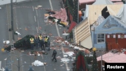 FILE - Policemen investigate the scene where a truck plowed into a crowded Christmas market in the German capital last night in Berlin, Germany, Dec. 20, 2016.