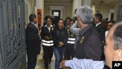 En esta foto proporcionada por la oficina de comunicaciones de la Corte Suprema de Perú, Keiko Fujimori es llevada a la cárcel con esposas luego de que el juez Richard Concepción dictaminó que debía ser detenida.