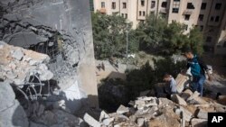 Palestinians inspect the damage of a destroyed house following a late night Israeli missile strike in town of Beit Lahiya, Northern Gaza Strip, May. 6, 2019.