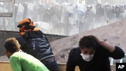 Protesters and police throw stones during clashes near Tahrir Square in Cairo, November 23, 2011.