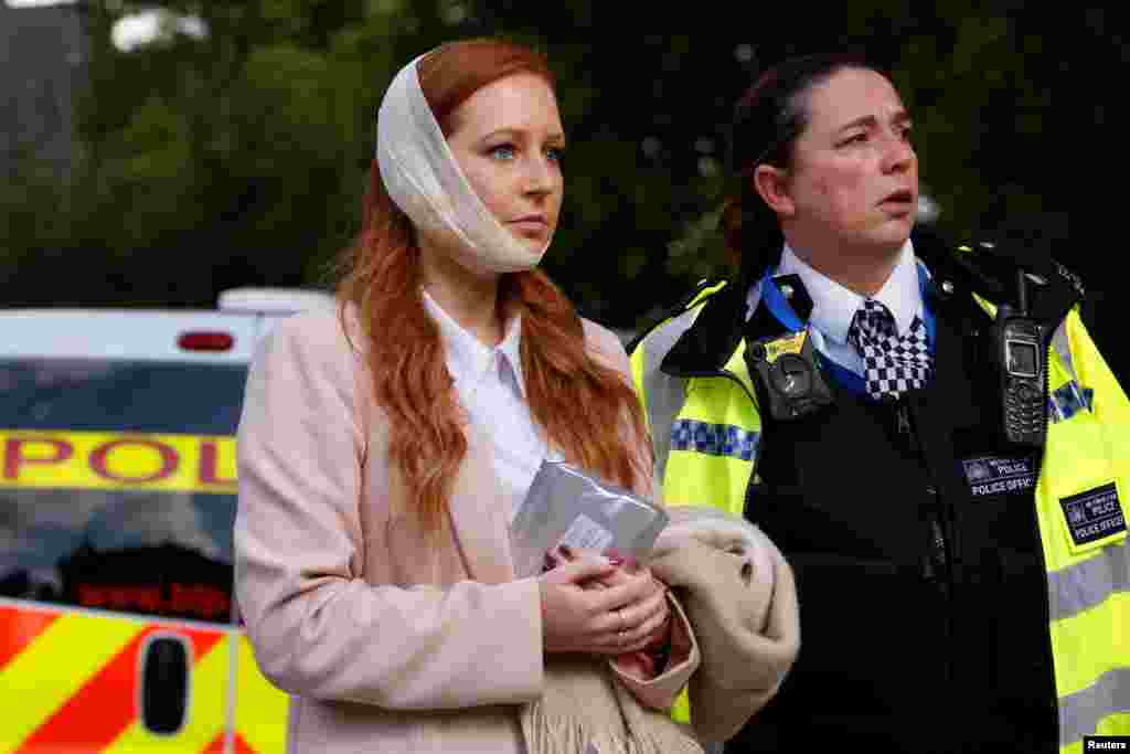 An injured woman is led away after an incident at Parsons Green underground station in London, Britain, September 15, 2017. 