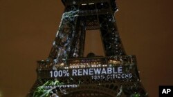 FILE - Artwork entitled 'One Heart One Tree' by artist Naziha Mestaoui is displayed on the Eiffel tower ahead of the 2015 Paris Climate Conference, in Paris. The Paris Agreement on climate change came into force Nov. 4, 2016.
