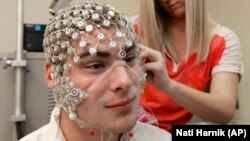 FILE - Kevin Real, a research assistant at the University of Nebraska's Center for Brain, Biology and Behavior in Lincoln, Nebraska, is fitted with a device to detect brain activity.