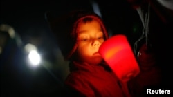 A boy takes part in a candlelight vigil in Newtown, Connecticut, December 21, 2012.