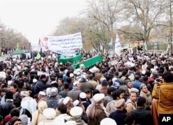 FILE - Afghan men carry the coffins of seven bodies from an ethnic Shi'ite minority, killed by the Islamic State group, in Ghazni province, Afghanistan, Nov. 10, 2015. The victims' bodies had been found in the Arghandab district of Zabul province, which borders Pakistan.