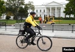 FILE - A member of the U.S. Secret Service patrols on bicycle in front of the North Lawn of the White House in Washington, Oct. 23, 2014.