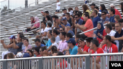 Tahir, wearing a USA hat, cheers on the opening day of the Uyghur American Cup