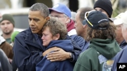 President Barack Obama, left, embraces Donna Vanzant, right, during a tour of a neighborhood effected by superstorm Sandy, Oct. 31, 2012 in Brigantine, N.J.