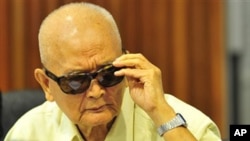 Noun Chea, former deputy secretary of the Communist Party of Kampuchea, adjusts his sunglasses during a joint hearing with other top Khmer Rouge leaders, Khieu Samphan, its head of state, and Ieng Thirith, former social affairs minister, at the outside th