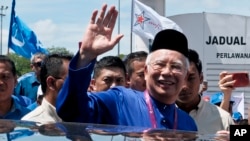 FILE - Malaysian Prime Minister Najib Razak waves to his supporters after his election nomination in Pekan, Pahang state, Malaysia, April 28, 2018. The reopening of a murder case could mean more trouble for Najib, who is being facing a corruption investigation.