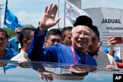 Malaysian Prime Minister Najib Razak waves to his supporters after his election nomination in Pekan, Pahang state, April 28, 2018.