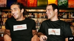 Gaby Bayram,kanan, warga Beirut yang juga pendiri www.savebeirut.org memakai T-shirt dengan tulisan yang berarti "Beirut, kota yang tidak pernah menyerah." (AP/Ben Curtis)