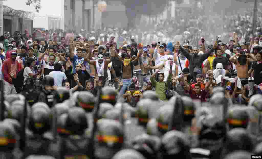 Supporters of opposition leader Henrique Capriles face off against riot police as they demonstrated for a recount of the votes in Sunday&#39;s election, in Caracas, April 15, 2013.&nbsp;
