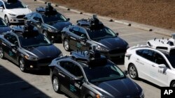 A group of self-driving Uber vehicles position themselves to take journalists on rides during a media preview at Uber's Advanced Technologies Center in Pittsburgh, Pennsylvania, Sept. 12, 2016.