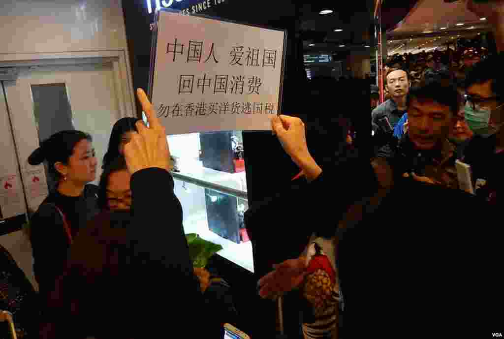 有示威者高舉標語包圍中國遊客，呼籲他們回中國消費。（美國之音湯惠芸攝）