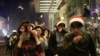 Warga mengenakan asesori untuk perayaan Natal menutup hidung dan matanya saat polisi menembakkan gas air mata untuk membubarkan para pengunjuk rasa di malam Natal di Hong Kong, 24 Desember 2019. 