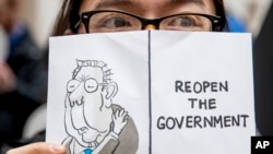 Federalna radnica koja je pogođana zatvaranjem vlade drži natpis na kojem piše "Otvorite vladu" za vrijeme protesta na Capitol Hillu (Foto: AP)