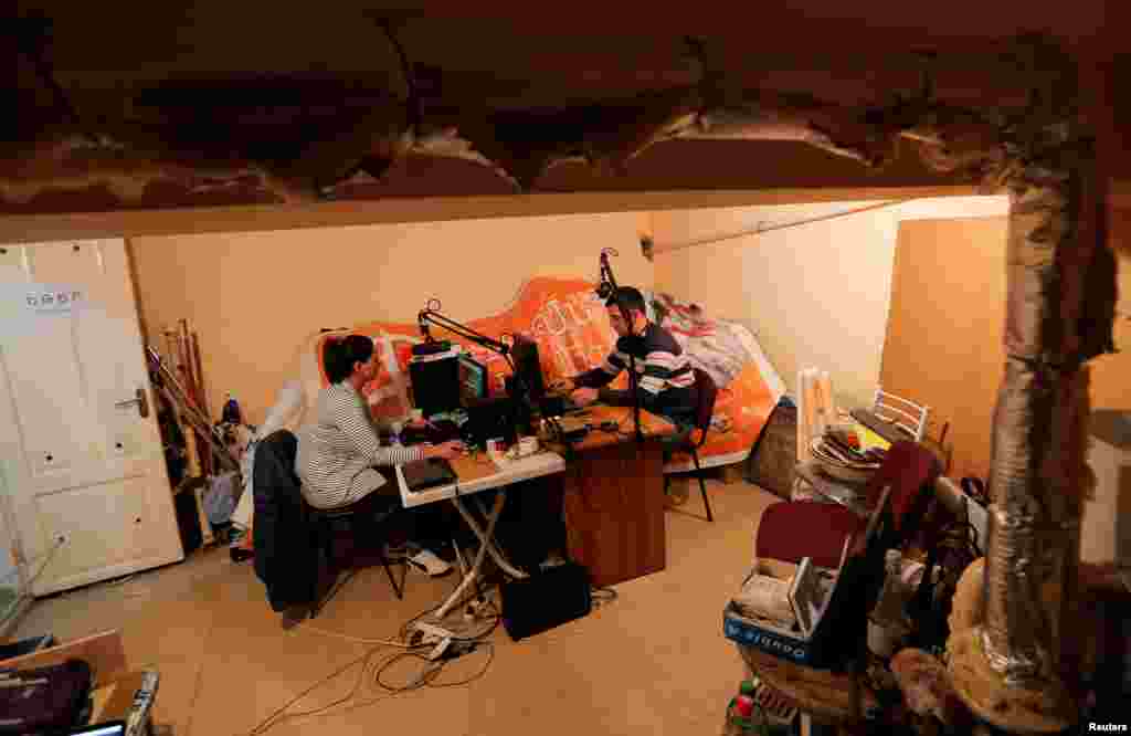 Radio journalists from a local public radio work at their studio located in a basement during the military conflict over the breakaway region of Nagorno-Karabakh, in Stepanakert.