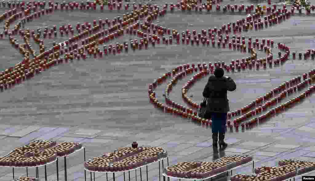 A woman prays at Independence Square in Kyiv. Ukraine is holding a day of mourning for the 13 people killed on Jan. 13, 2015, when a passenger bus came under heavy fire in eastern part of the country.