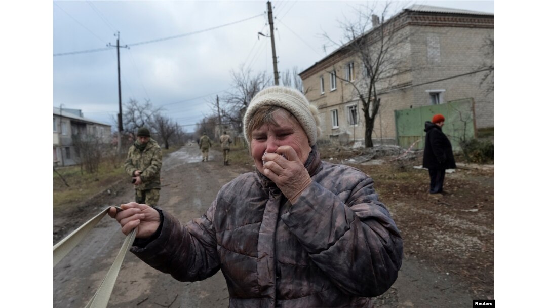A woman reacts near her house, which was damaged by recent shelling, in Novoluhanske, Ukraine, Dec. 19, 2017.