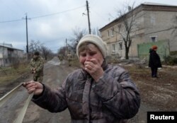 A woman reacts near her house, which was damaged by recent shelling, in Novoluhanske, Ukraine, Dec. 19, 2017.
