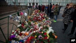 People look at flowers left for the plane crash victims at Dvortsovaya (Palace) Square in St. Petersburg, Russia, Nov. 2, 2015. 