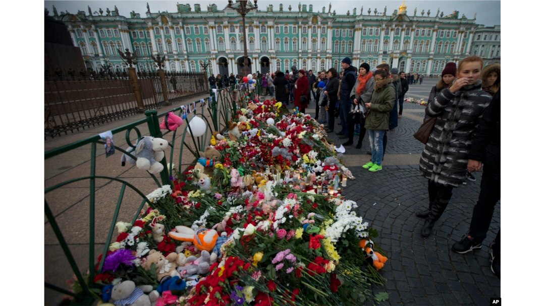 People look at flowers left for the plane crash victims at Dvortsovaya (Palace) Square in St. Petersburg, Russia, Nov. 2, 2015.