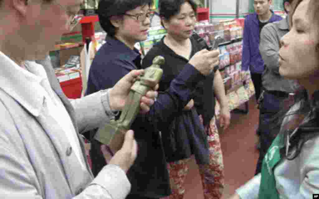 游客在商店里挑选毛雕像