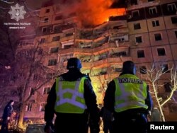 Police officers stand in front of an apartment building damaged by a Russian missile strike in Kryvyi Rih, Dnipropetrovsk region, Ukraine, March 12, 2024. (Press service of the Patrol Police of Kryvyi Rih/Handout)