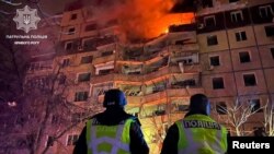 Police officers stand in front of an apartment building damaged by a Russian missile attack in Krivoy Rog, Dnipropetrovsk region, Ukraine, March 12, 2024.  (Handout provided by Krivorog Patrol Police News Service/Reuters) )