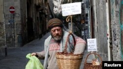 A man takes food from a basket as Italy struggles to contain the spread of coronavirus disease (COVID-19), in Naples.