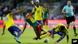 Le Gabonais Serge Ngouali, à gauche, et André Biyogo Poko, à droite, bataillent autour du ballon avec le Camerounais Edgar Salli lors du match du groupe A de la Coupe d’Afrique des nations entre le Gabon et le Cameroun au stade de l’Amitié, à Libreville, 