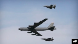 Un bombardero B-52 vuela sobre la base Osan en Pyeongtaek, Corea del Sur, escoltado por dos aviones caza.