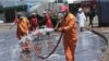 Harare City Council workers disinfect a bus terminal, in Harare, Zimbabwe, April, 1, 2020. 